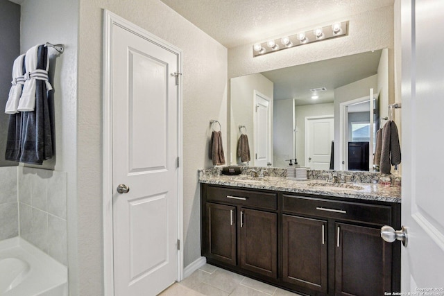 bathroom with vanity, tile patterned floors, and a textured ceiling