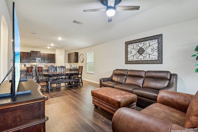 living room featuring ceiling fan and dark hardwood / wood-style flooring