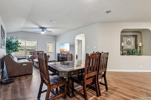 dining space with ceiling fan, lofted ceiling, and dark hardwood / wood-style flooring