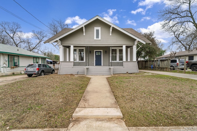 bungalow-style house featuring covered porch and a front lawn