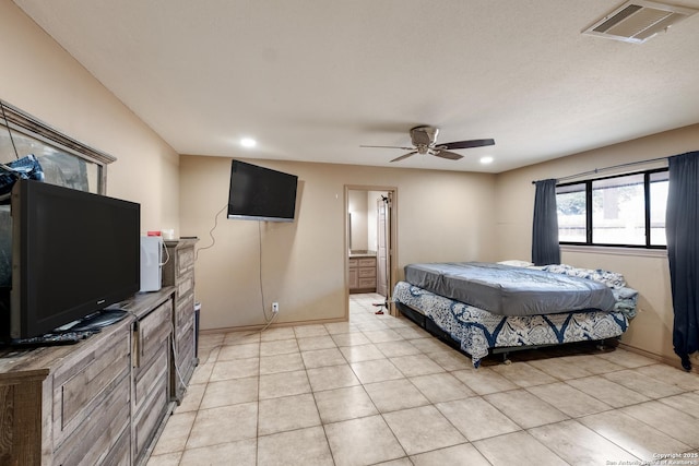 bedroom with light tile patterned floors, ensuite bath, and ceiling fan