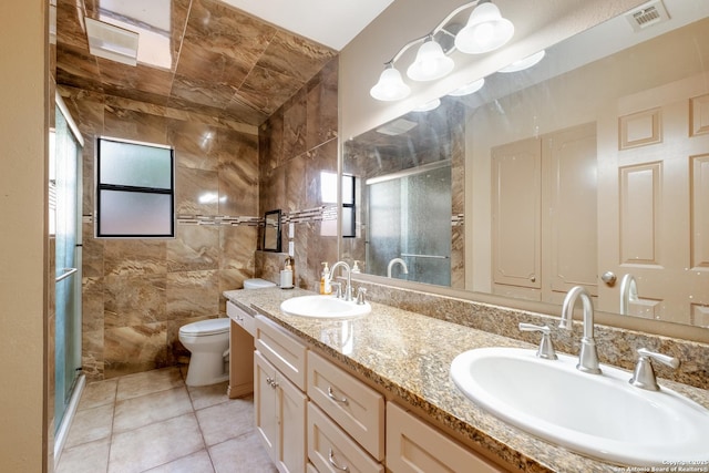 bathroom with vanity, toilet, a shower with shower door, and tile patterned flooring