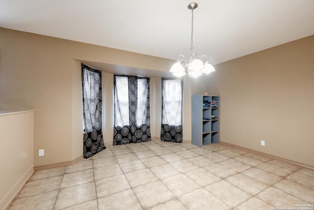 spare room with light tile patterned floors and an inviting chandelier