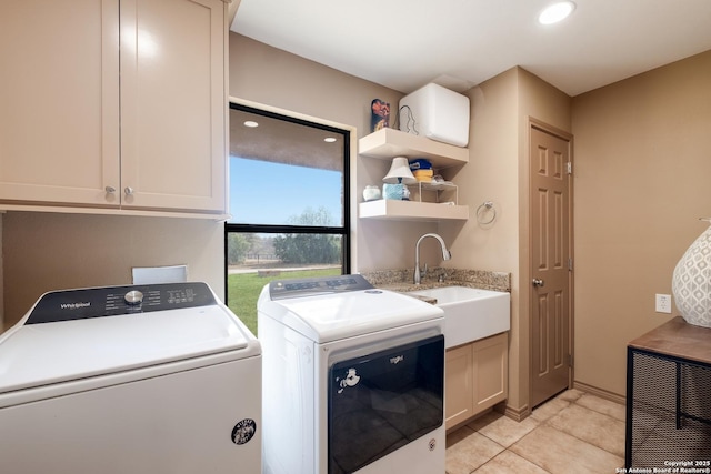 laundry area with cabinets, light tile patterned floors, sink, and washing machine and clothes dryer