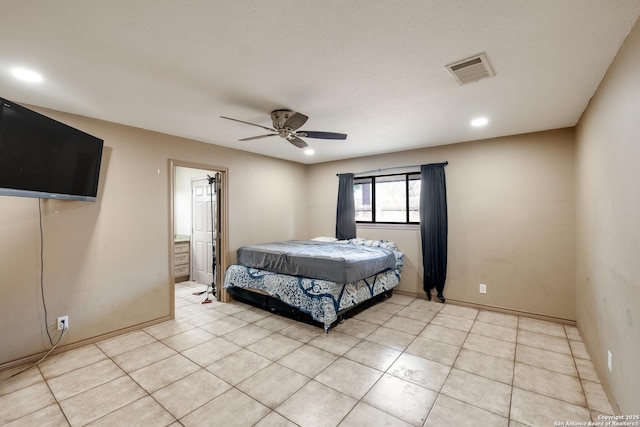 bedroom with light tile patterned floors, ceiling fan, and ensuite bath