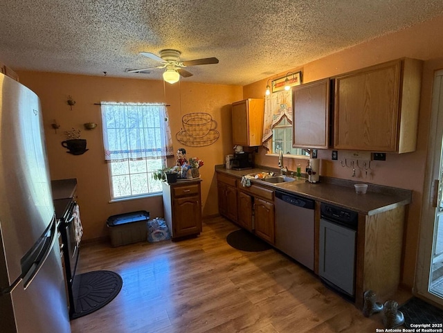 kitchen featuring hardwood / wood-style flooring, appliances with stainless steel finishes, sink, and a textured ceiling