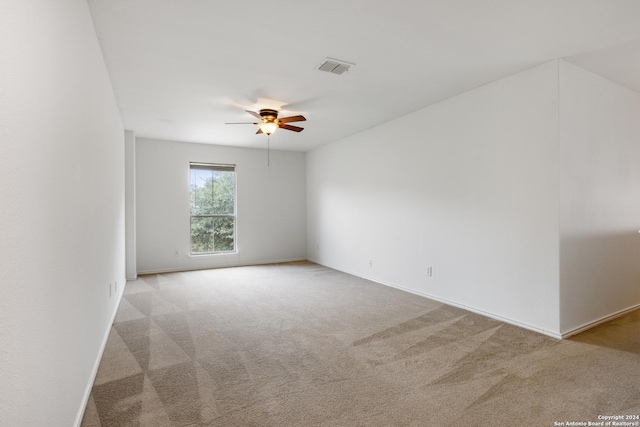 spare room with light colored carpet and ceiling fan