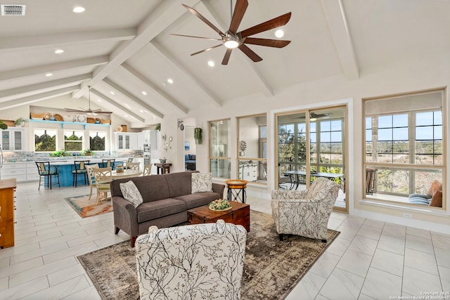 living area featuring ceiling fan, beamed ceiling, visible vents, and a healthy amount of sunlight