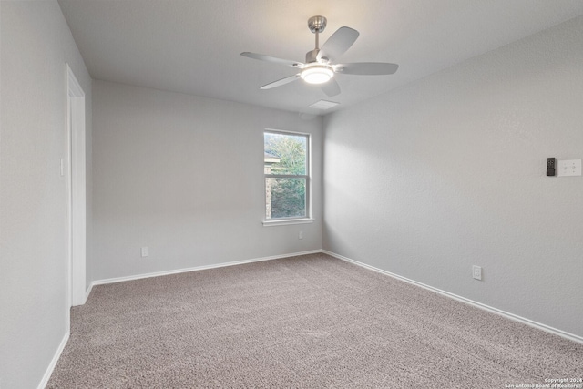 spare room featuring ceiling fan and carpet