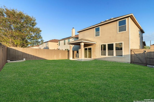 rear view of house with a yard and a patio