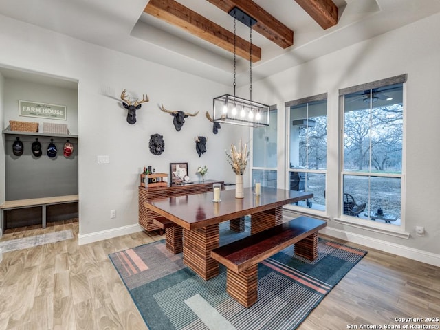 dining room with wood-type flooring, an inviting chandelier, and beam ceiling