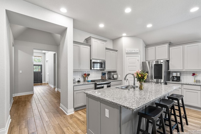 1905 High Bank, Seguin, TX 78155 - kitchen featuring appliances with stainless steel finishes, a sink, tasteful backsplash, baseboards, and a breakfast bar