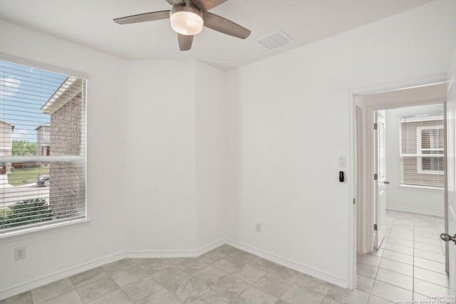 tiled empty room featuring ceiling fan