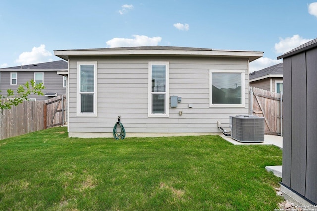 back of property featuring a yard and central air condition unit