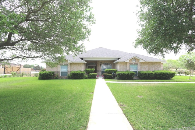 ranch-style house featuring a front lawn, roof with shingles, and brick siding