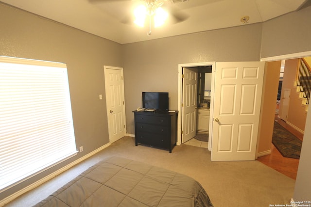 bedroom featuring light carpet, baseboards, and a ceiling fan
