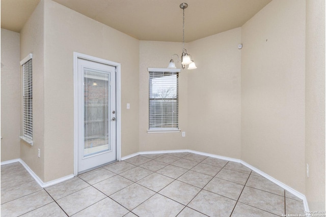 unfurnished dining area with a chandelier and light tile patterned floors