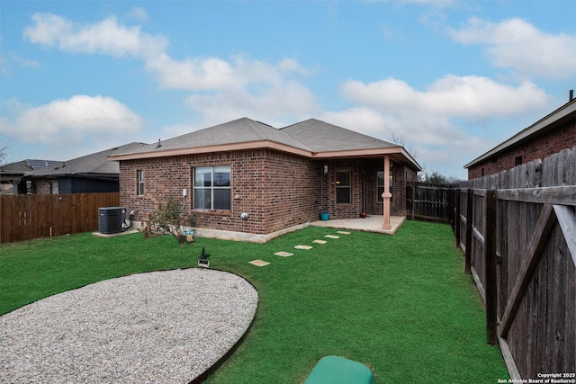 back of house with central AC, a patio area, and a lawn