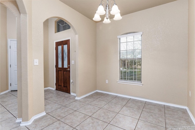 foyer entrance with a chandelier and light tile patterned flooring