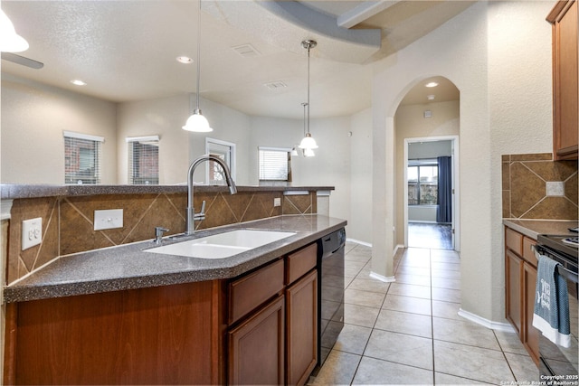 kitchen featuring pendant lighting, sink, tasteful backsplash, and black appliances