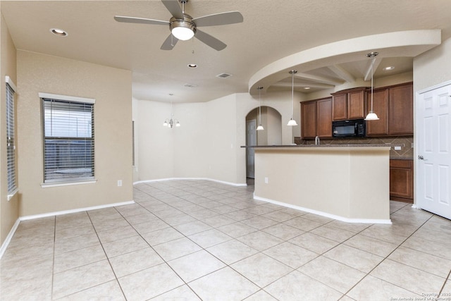 kitchen with decorative light fixtures, ceiling fan with notable chandelier, decorative backsplash, and light tile patterned floors