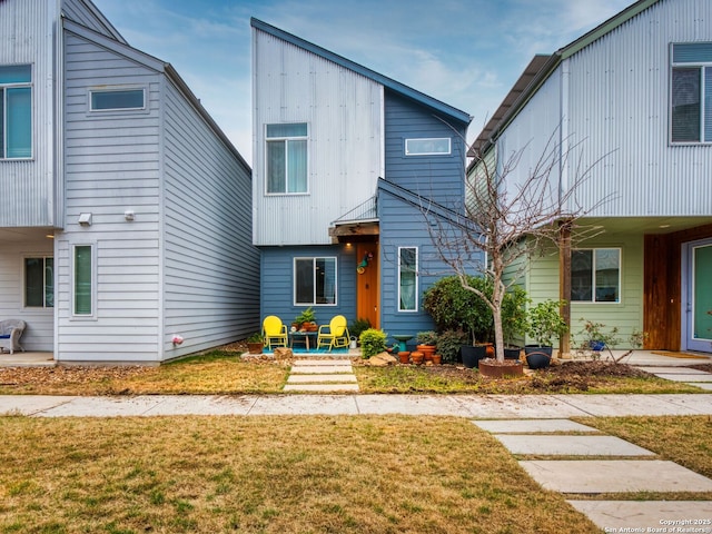 view of front of property featuring a front lawn and a patio