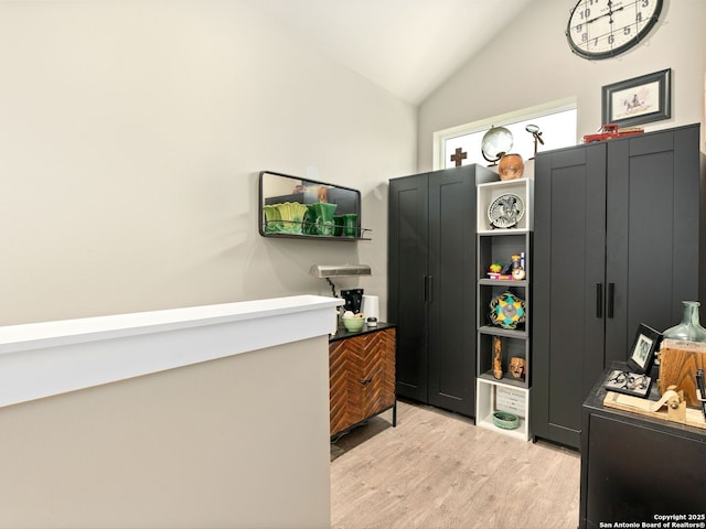 interior space featuring lofted ceiling and light hardwood / wood-style floors