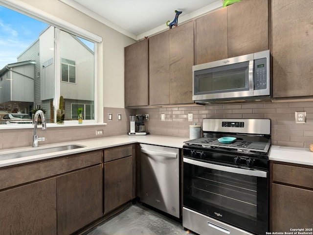 kitchen featuring appliances with stainless steel finishes, sink, dark brown cabinetry, and decorative backsplash