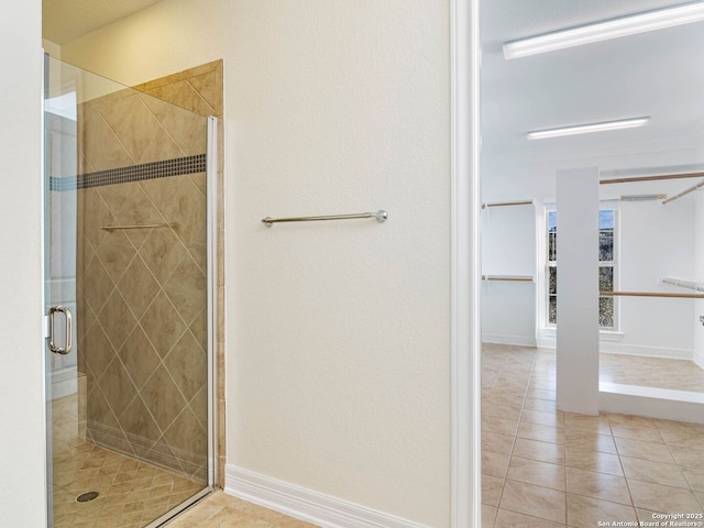 bathroom with tile patterned flooring and a shower with shower door