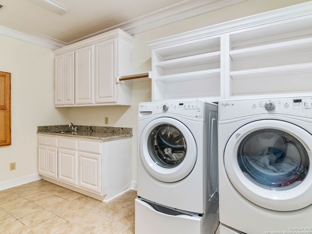 laundry room featuring light tile patterned floors, sink, crown molding, cabinets, and washing machine and clothes dryer