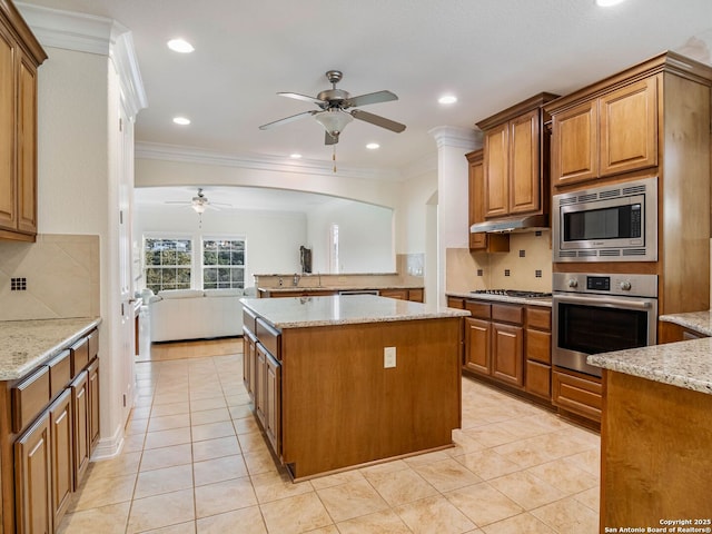 kitchen featuring light tile patterned floors, light stone countertops, a center island, and appliances with stainless steel finishes