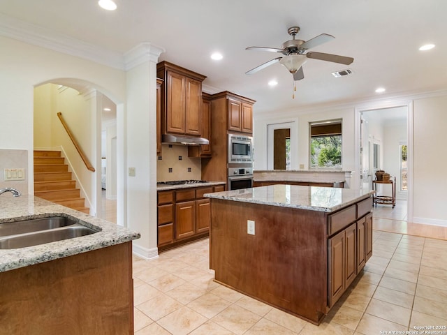 kitchen with sink, backsplash, ornamental molding, stainless steel appliances, and light stone countertops