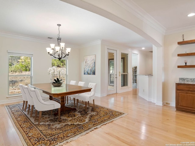 dining area featuring ornamental molding, a chandelier, and light hardwood / wood-style flooring