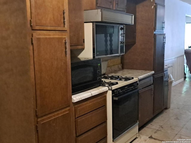 kitchen featuring white gas range and tile countertops