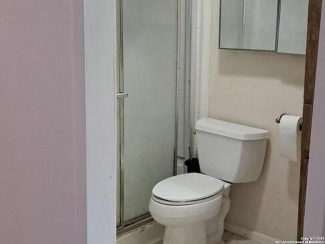 bathroom with an enclosed shower and toilet