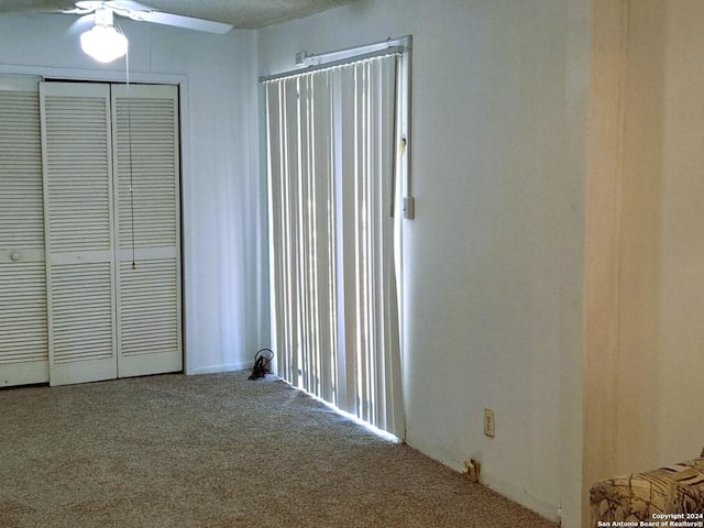 interior space featuring a closet, ceiling fan, and carpet