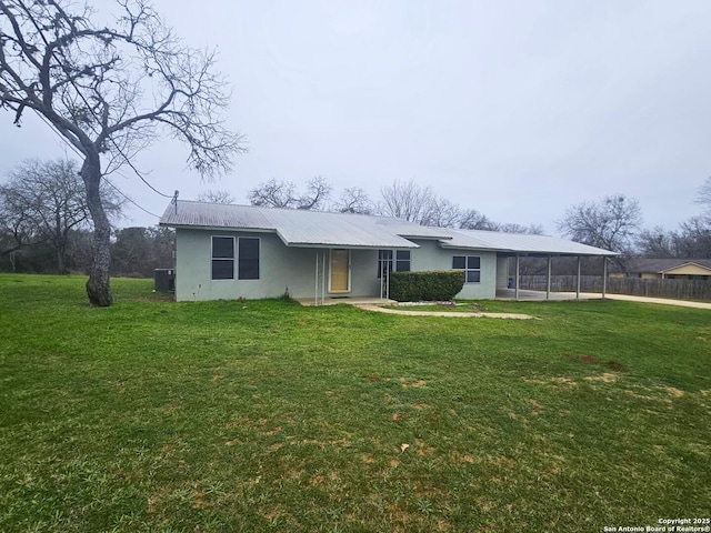 ranch-style house featuring central AC unit and a front lawn