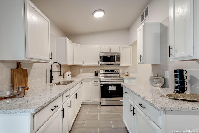 kitchen with white cabinetry, appliances with stainless steel finishes, sink, and backsplash