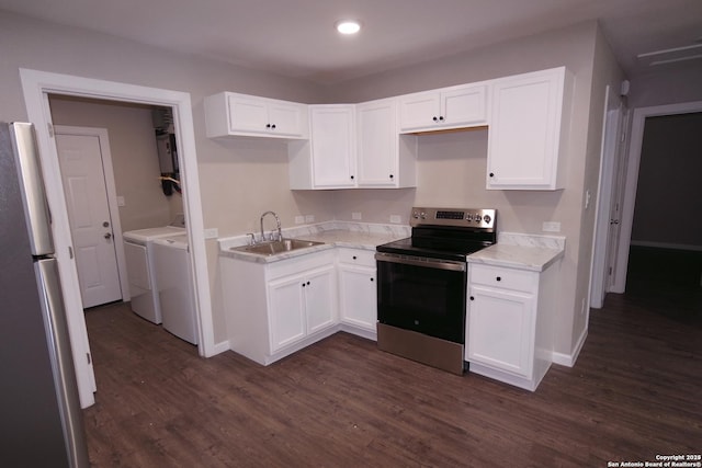 kitchen with independent washer and dryer, appliances with stainless steel finishes, sink, and white cabinets