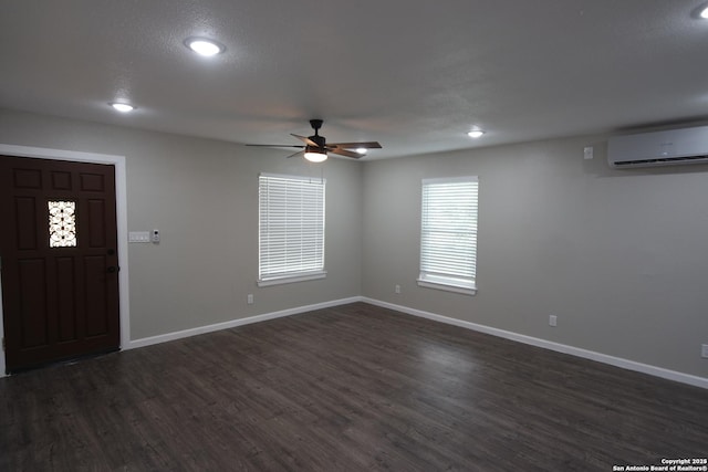 entrance foyer with ceiling fan, dark hardwood / wood-style flooring, and a wall mounted AC