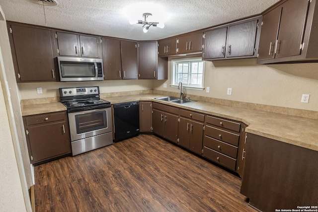 kitchen featuring dark brown cabinetry, sink, a textured ceiling, appliances with stainless steel finishes, and dark hardwood / wood-style floors