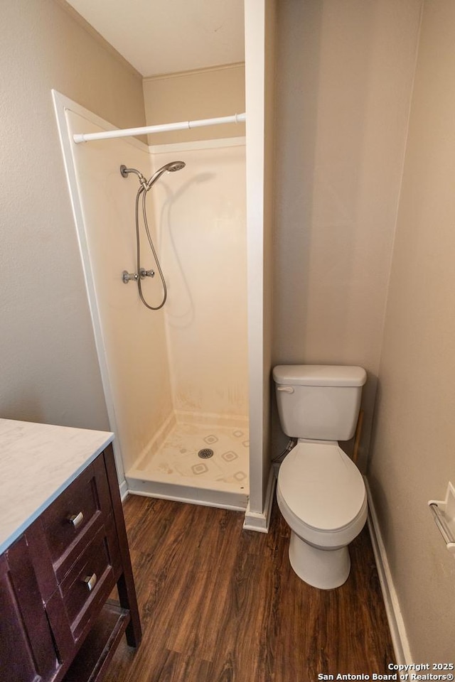 bathroom featuring vanity, toilet, hardwood / wood-style floors, and a shower