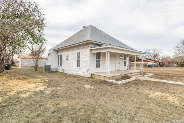 exterior space with covered porch, a front lawn, and central air condition unit