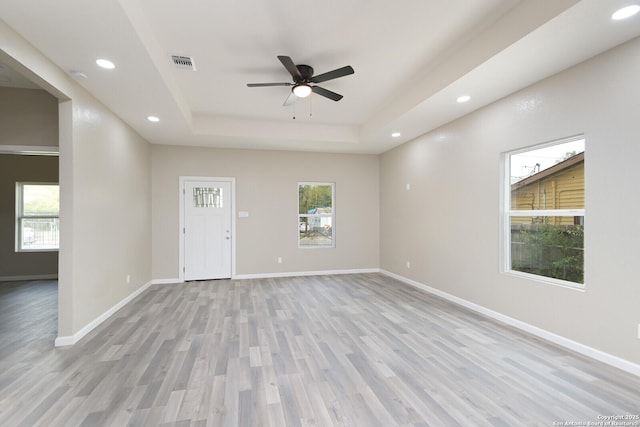 interior space featuring a tray ceiling, light hardwood / wood-style floors, and ceiling fan