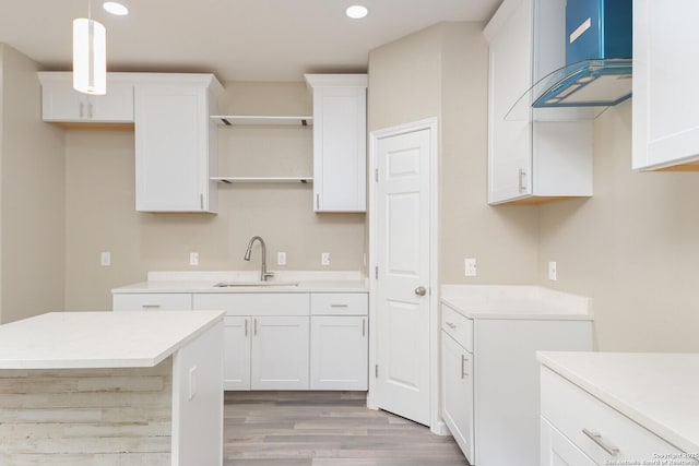 kitchen featuring hanging light fixtures, white cabinetry, and sink