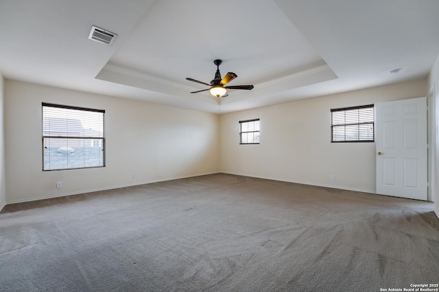 carpeted spare room featuring ornamental molding, ceiling fan, and a tray ceiling