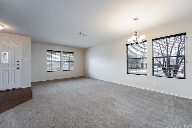 entryway featuring carpet and a chandelier