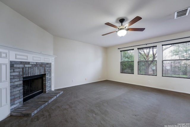 unfurnished living room featuring ceiling fan, a fireplace, and dark colored carpet