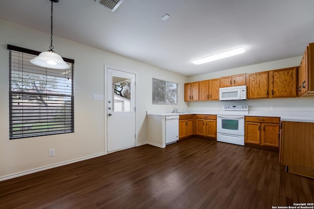 kitchen featuring hanging light fixtures, white appliances, and dark hardwood / wood-style floors