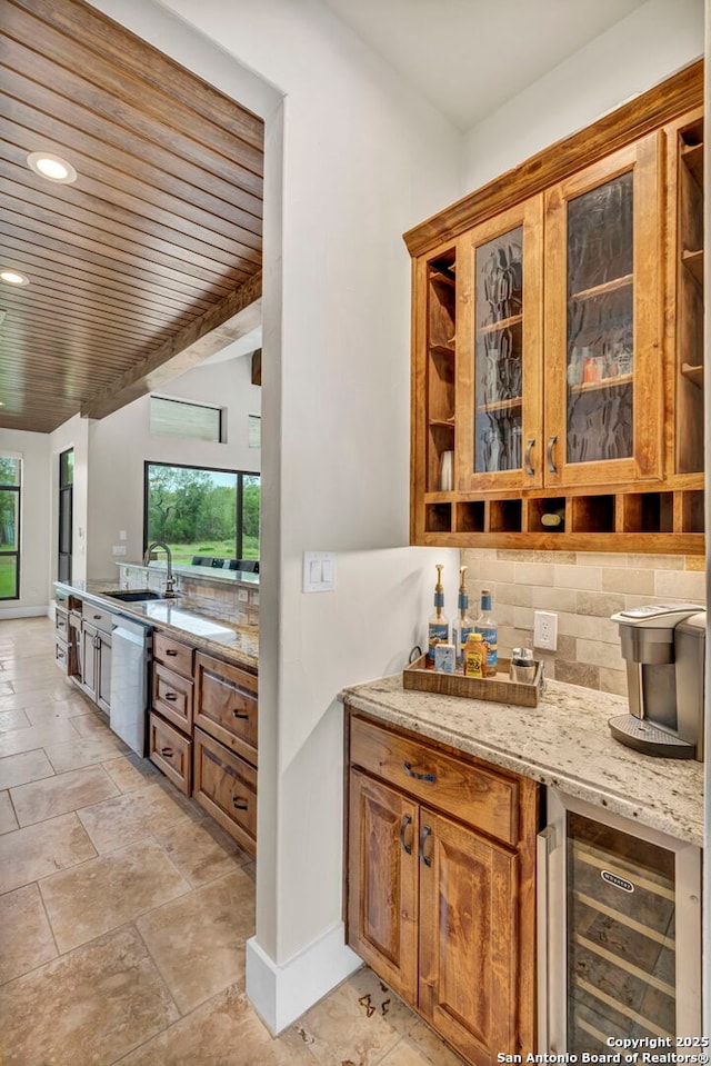 bar featuring wine cooler, sink, tasteful backsplash, stainless steel dishwasher, and light stone countertops